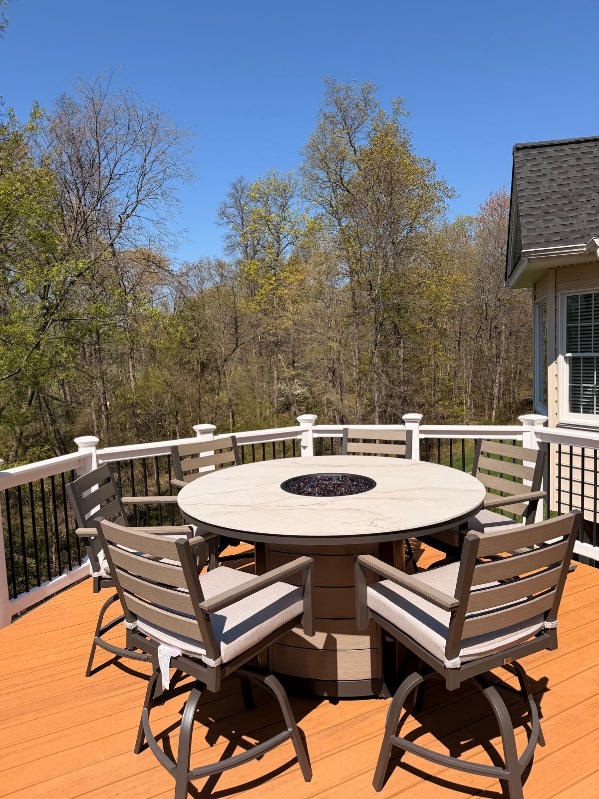 Outdoor fire table and chairs assembled on a deck