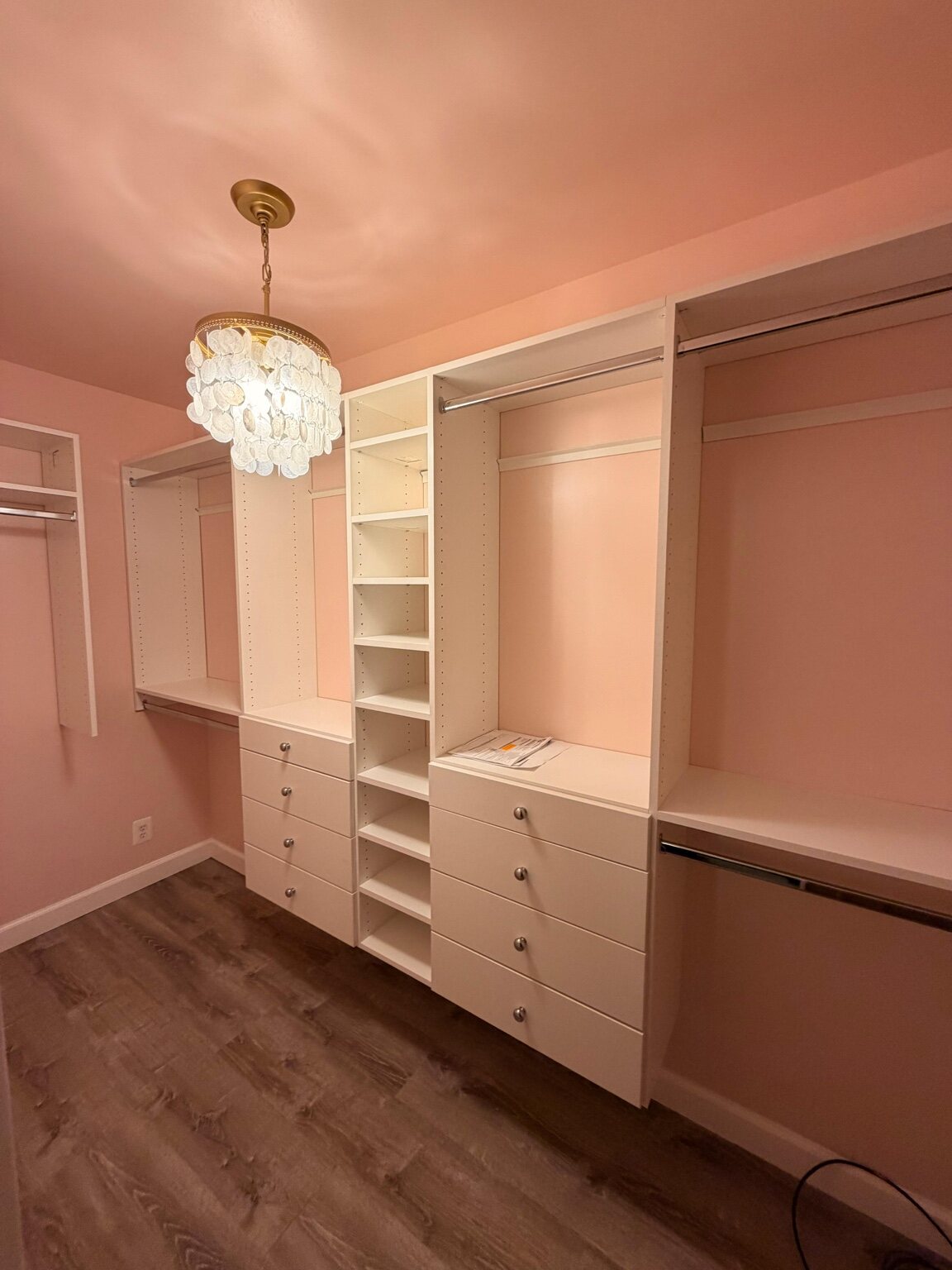 Custom closet installed in a pink dressing room